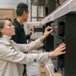 A man and woman examining drawers in a furniture store, exploring options.