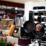 A vibrant selection of modern kitchen utensils including pans, blenders, and accessories.