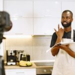 A video blogger records a cooking session in a modern kitchen, sharing recipes.