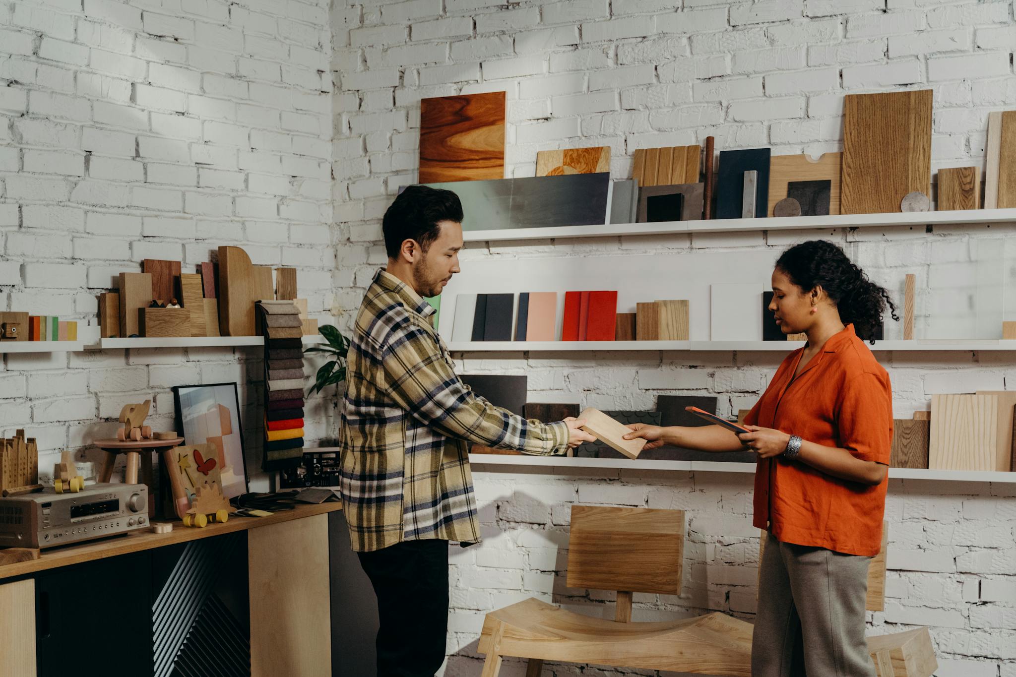 Man and woman selecting wooden samples in a chic, modern store.