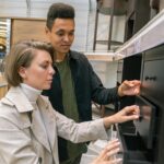 Young couple browsing furniture options in a home goods store aisle.